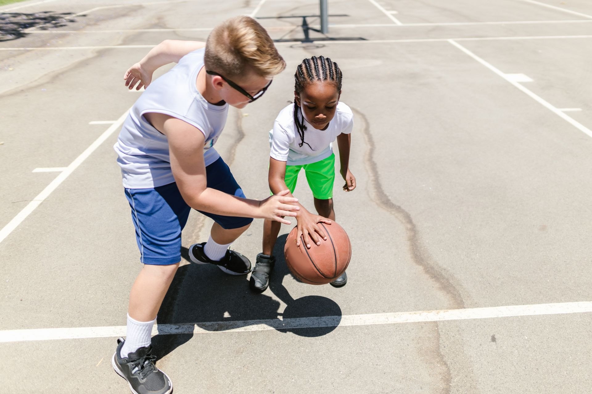 Children practicing basketball outdoors
